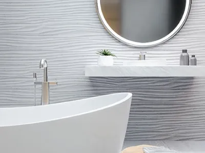 Salle de bain moderne avec baignoire blanche, miroir rond et lavabo flottant