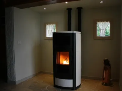 Poêle à granulés blanc moderne dans un salon avec fenêtres et cheminée fonctionnelle